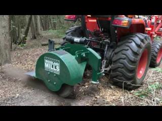 Tractor mounted stump grinder.